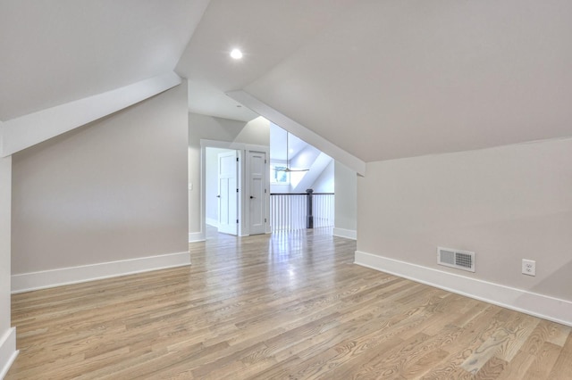 additional living space with light hardwood / wood-style flooring and vaulted ceiling