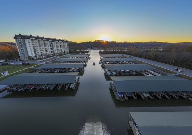 aerial view at dusk featuring a water view