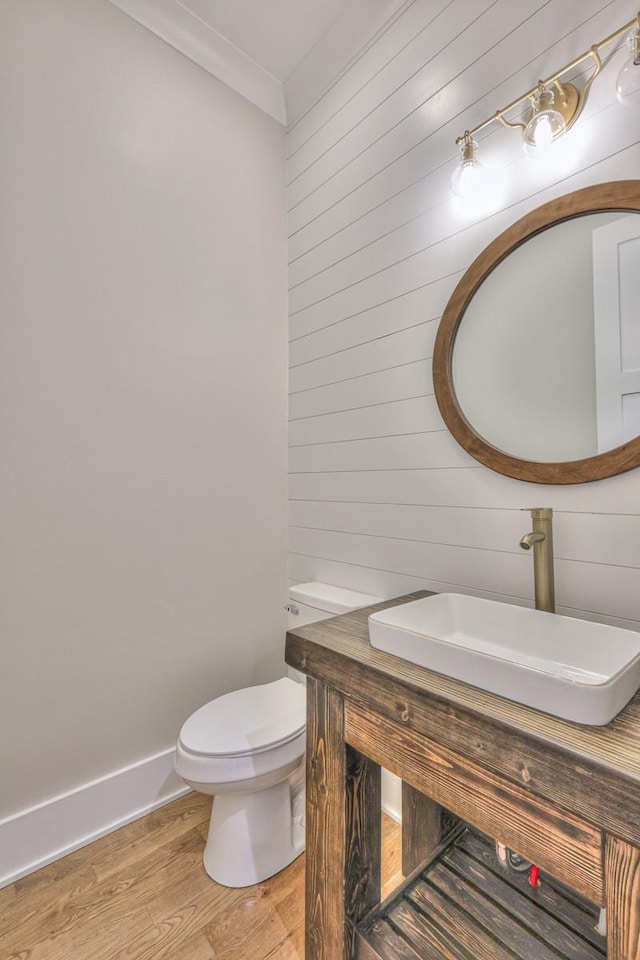 bathroom featuring crown molding, hardwood / wood-style floors, vanity, and toilet