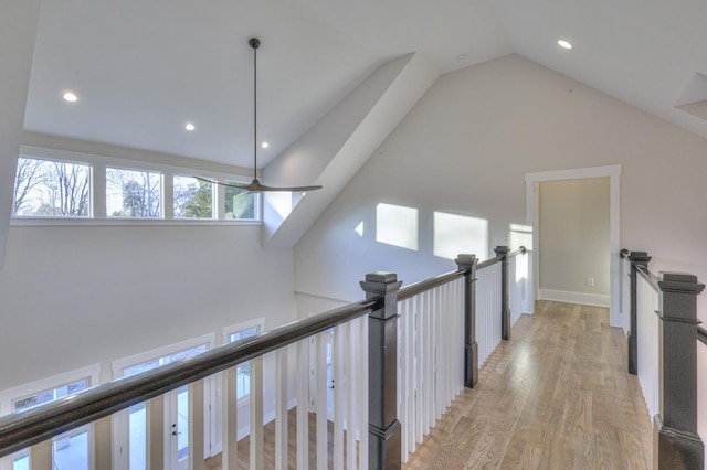 hall featuring light hardwood / wood-style floors and high vaulted ceiling