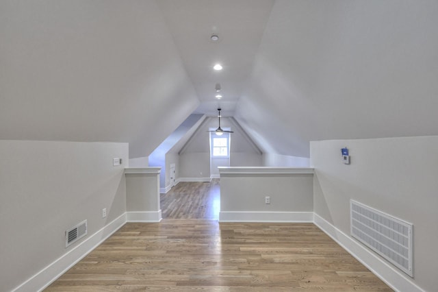 additional living space with light wood-type flooring and vaulted ceiling