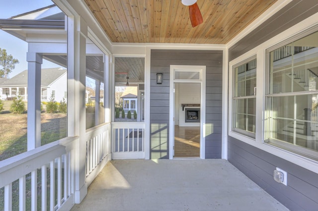 sunroom with ceiling fan and wood ceiling