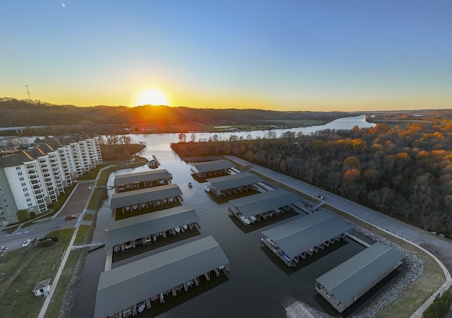 aerial view at dusk featuring a water view