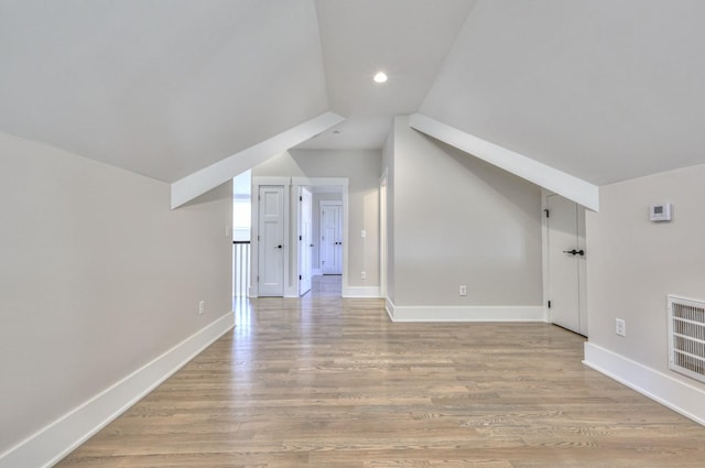 bonus room with light hardwood / wood-style floors and vaulted ceiling