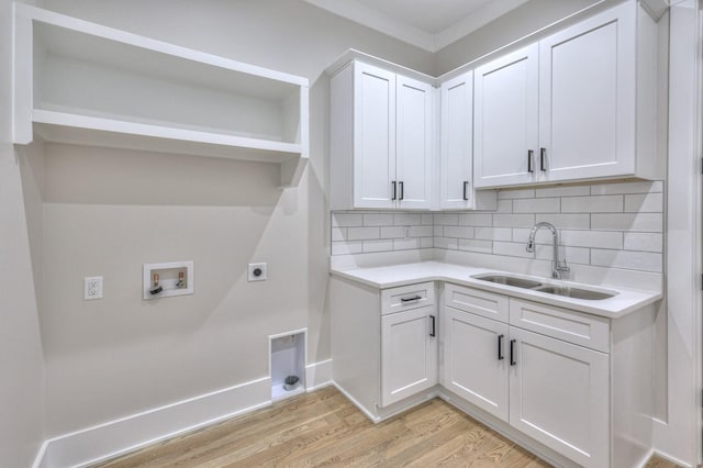 washroom with sink, cabinets, hookup for an electric dryer, hookup for a washing machine, and light wood-type flooring