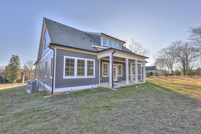 view of front of house with a front lawn, central AC unit, and a patio area