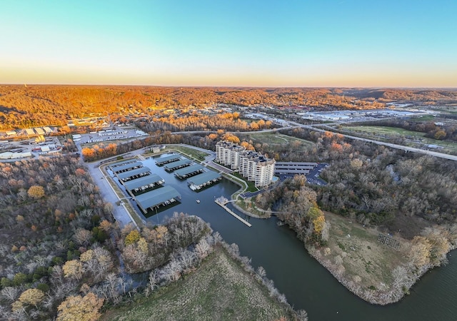 aerial view at dusk featuring a water view