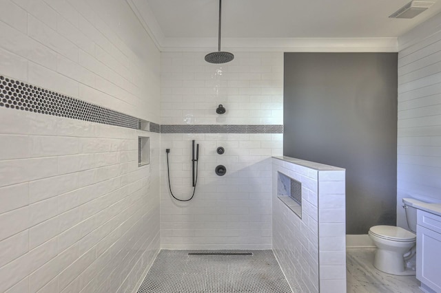 bathroom with a tile shower and toilet