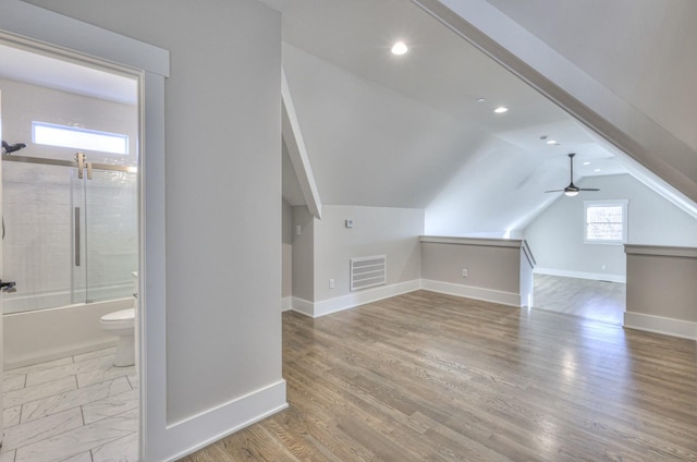 bonus room with ceiling fan, lofted ceiling, and light wood-type flooring