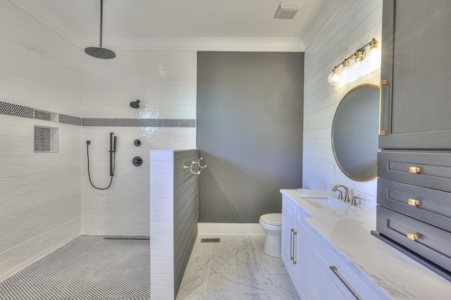 bathroom featuring vanity, toilet, a tile shower, and ornamental molding