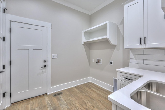 laundry room with cabinets, sink, washer hookup, light wood-type flooring, and hookup for an electric dryer