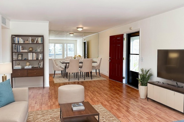 living room with light hardwood / wood-style floors and ornamental molding