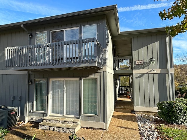 rear view of house with a balcony and cooling unit