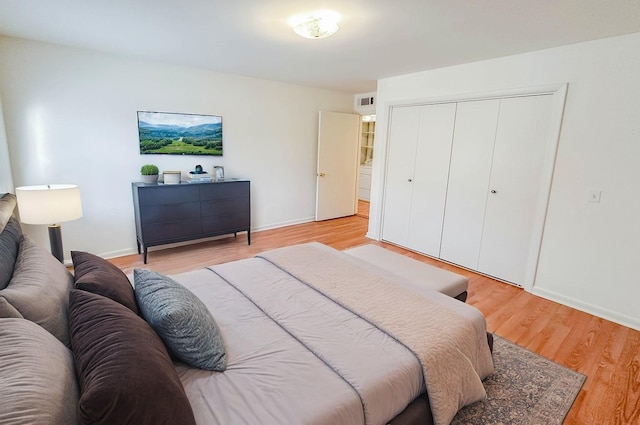 bedroom with light hardwood / wood-style floors and a closet