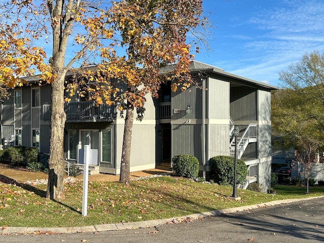 view of front of house with a balcony and a front yard