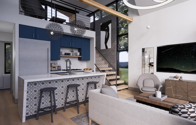3525 Garner Rd Unit 2, Chattanooga, TN 37406 - kitchen with blue cabinetry, a high ceiling, light wood finished floors, light countertops, and a kitchen breakfast bar