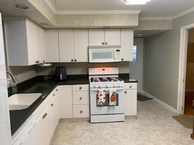 kitchen with white cabinetry, sink, crown molding, and white appliances