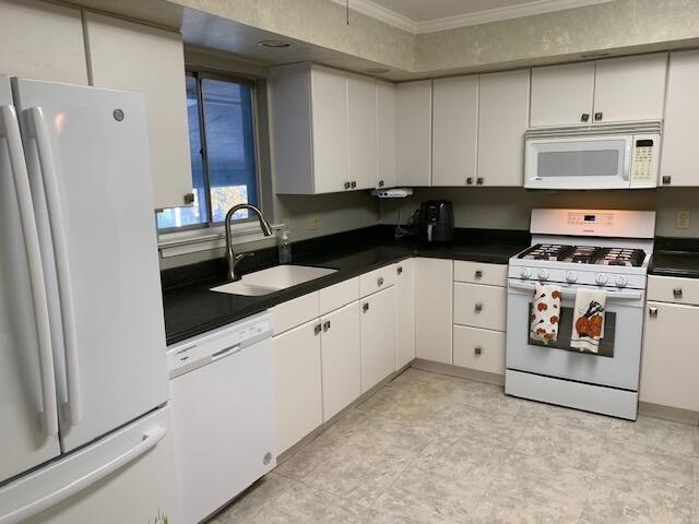 kitchen featuring white cabinetry, sink, and white appliances