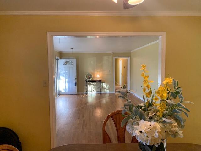 corridor featuring hardwood / wood-style flooring and ornamental molding