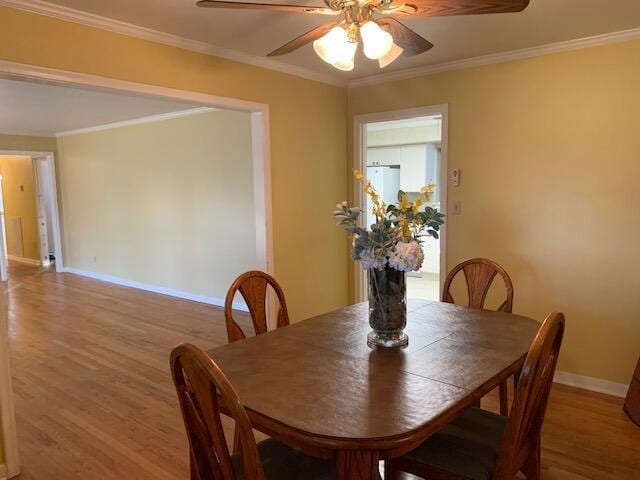 dining room featuring hardwood / wood-style floors, ceiling fan, and crown molding