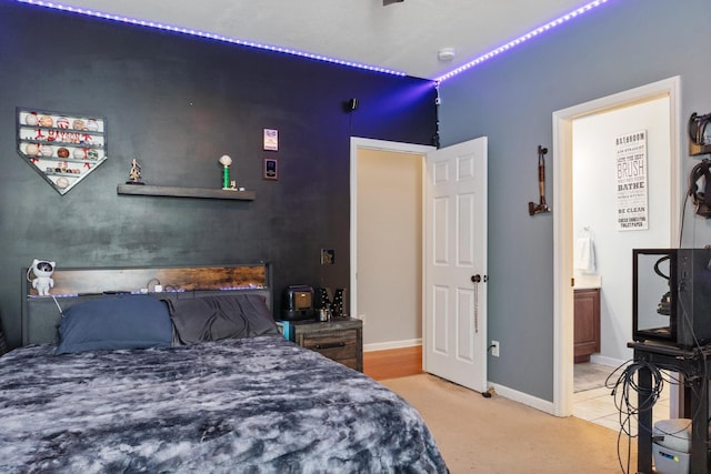 bedroom with ensuite bath and carpet