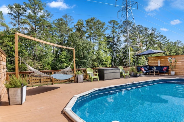 view of swimming pool with an outdoor living space and a deck