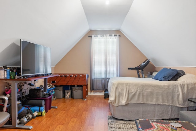 bedroom with wood-type flooring and vaulted ceiling