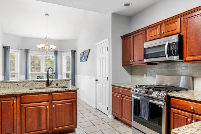 kitchen with an inviting chandelier, sink, light tile patterned floors, appliances with stainless steel finishes, and decorative light fixtures