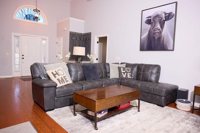 living room with baseboards, a high ceiling, and wood-type flooring
