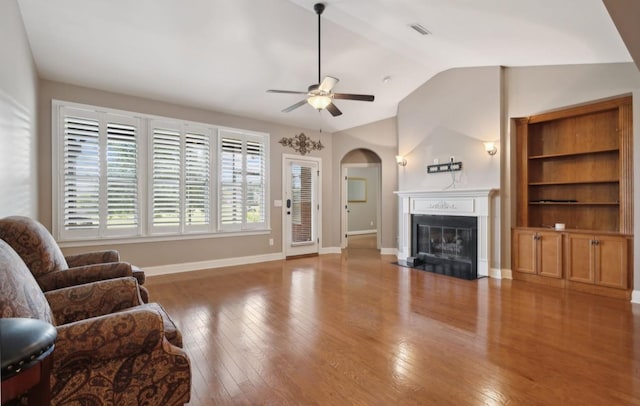 living room featuring ceiling fan, wood-type flooring, and vaulted ceiling