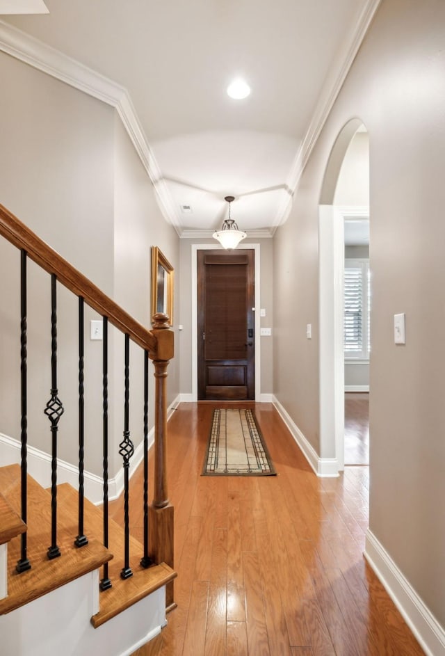 foyer with hardwood / wood-style floors and ornamental molding