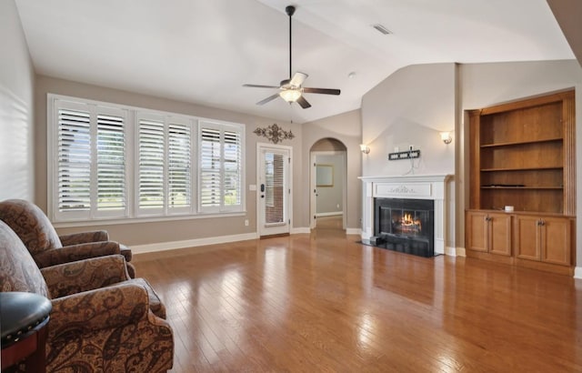 living room featuring hardwood / wood-style flooring, vaulted ceiling, and ceiling fan