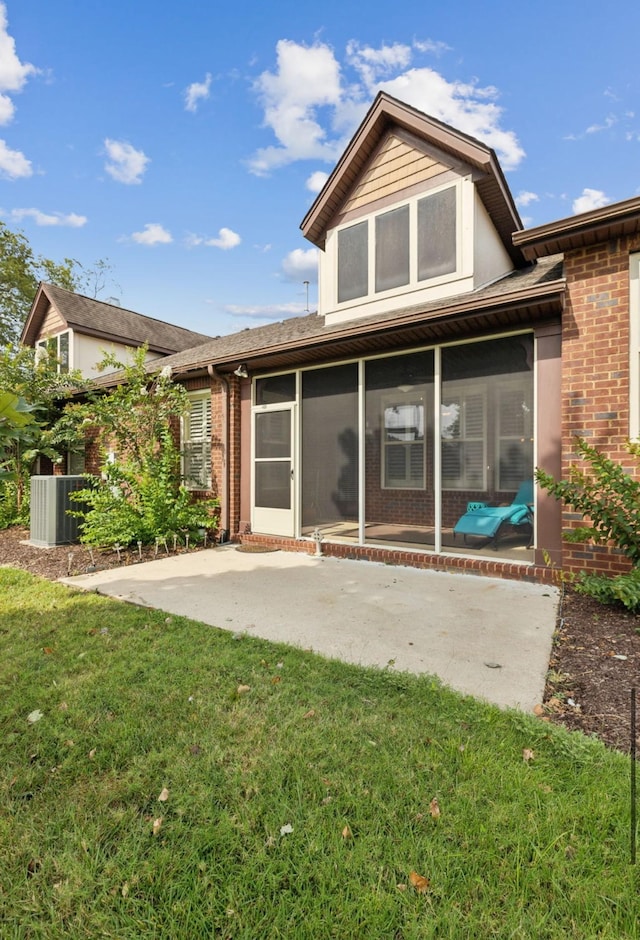 rear view of house with a patio, a sunroom, and a lawn