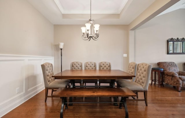 dining room featuring a tray ceiling, crown molding, dark hardwood / wood-style flooring, and a notable chandelier