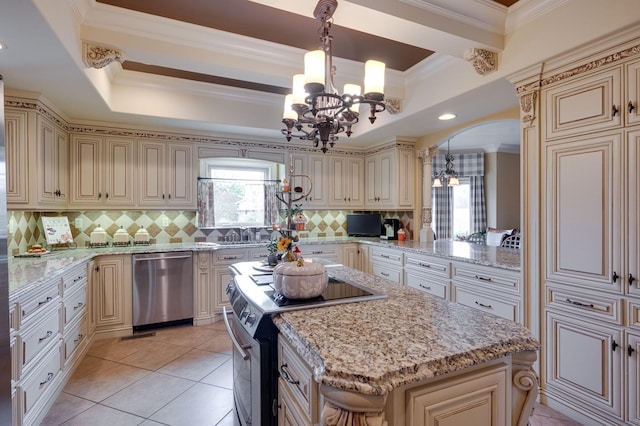 kitchen featuring cream cabinetry, decorative light fixtures, ornamental molding, and appliances with stainless steel finishes