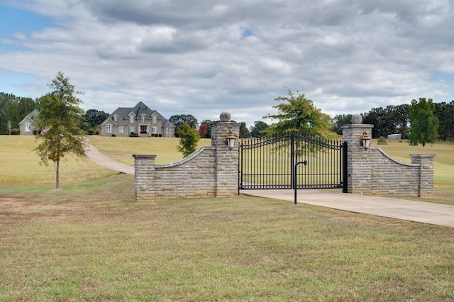 view of gate with a lawn