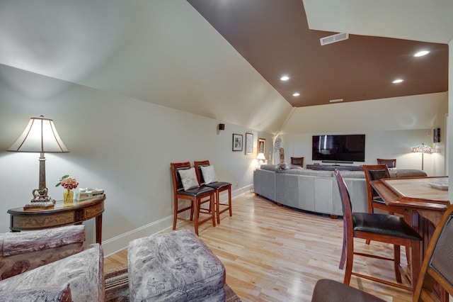 living room with vaulted ceiling and light wood-type flooring