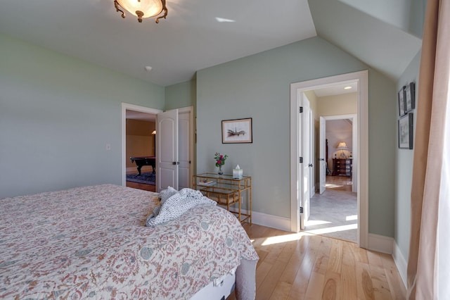 bedroom with light hardwood / wood-style floors and vaulted ceiling