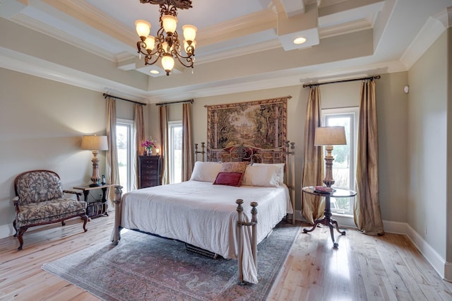 bedroom with hardwood / wood-style flooring, a notable chandelier, ornamental molding, and a tray ceiling