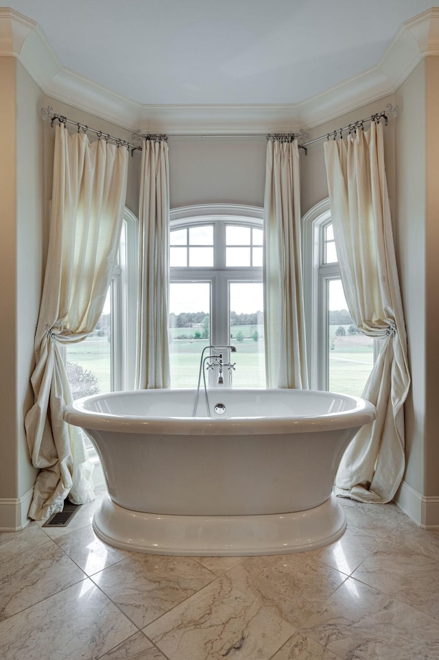 bathroom with crown molding, a washtub, and a water view