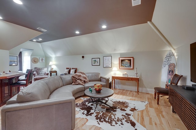 living room with light hardwood / wood-style flooring and vaulted ceiling