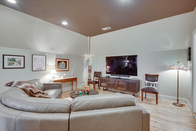 living room featuring light hardwood / wood-style flooring and lofted ceiling