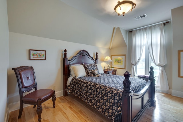 bedroom featuring light hardwood / wood-style flooring and lofted ceiling