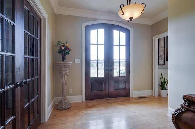 foyer entrance featuring french doors, light hardwood / wood-style floors, and ornamental molding