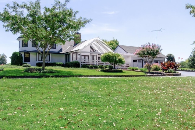 view of front of home with a pergola and a front lawn