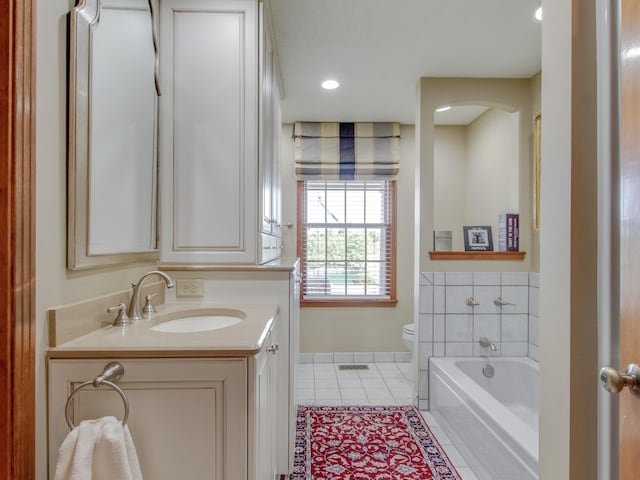 bathroom with tile patterned flooring, vanity, toilet, and a tub