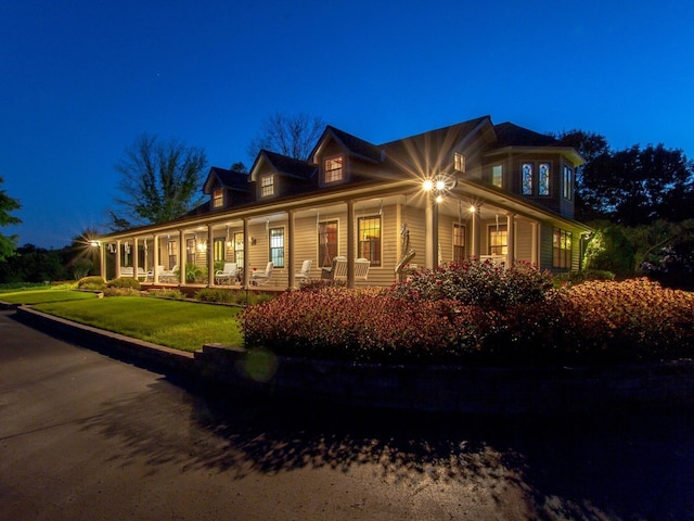 view of front of home with covered porch and a lawn