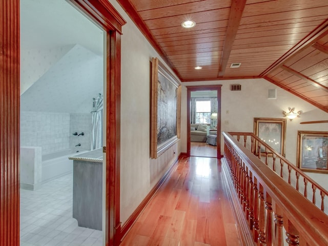 corridor featuring light hardwood / wood-style floors, vaulted ceiling, and wood ceiling