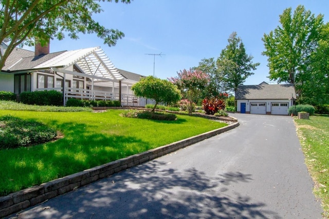 view of front of home featuring a pergola, a garage, and a front lawn