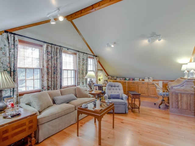 living room featuring lofted ceiling with beams, light hardwood / wood-style floors, and track lighting